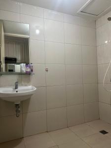 ein Bad mit einem Waschbecken und einem Spiegel in der Unterkunft Tanglin Orchard Apartment by Kondoku in Lontar