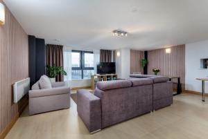 a living room with two couches and a television at Urban Oasis: Heart of City by Train in Leeds