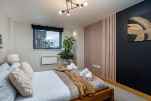 een slaapkamer met een bed met een deken erop bij Urban Oasis: Heart of City by Train in Leeds