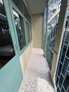pasillo de un edificio con puertas verdes y suelo de baldosa en Bang Wa House - MRT Bang Wa Station, en Bangkok