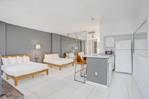 a hotel room with two beds and a kitchen at Walk to the Beach Seasonal Vacation Home Pool in Hallandale Beach