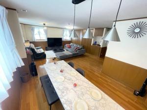 ein Wohnzimmer mit einem Tisch und einem Sofa in der Unterkunft No1 Private Hotel&Villa Aomoril 186平米貸切 最大12名 in Aomori