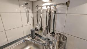 a kitchen sink with utensils hanging on a wall at Stylisches Villa-Apartment in Schlossgartennähe in Schwerin