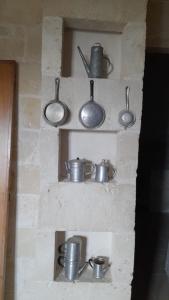 a group of pots and pans on a brick wall at Il Vecchio Mulino in Modugno