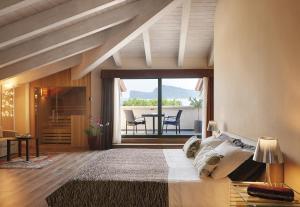 ein Schlafzimmer mit einem großen Bett und einem Tisch mit Stühlen in der Unterkunft Hotel Ristorante Sogno in San Felice del Benaco