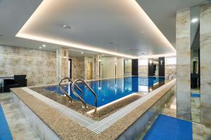 a swimming pool in a hotel room with a swimming pool at Aisha Bibi Hotel & Spa in Astana