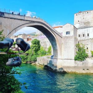 een brug over een rivier met mensen die erop lopen bij Mostar Delight - Next to riverside! in Mostar