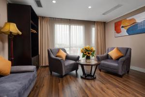 a living room with two chairs and a table with flowers at Beryl Charm Hotel and Spa in Hanoi