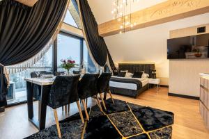 Białka TatrzanskaAparthotel Diamond SPA Aqua的一间带床的卧室和一间带桌子的餐厅