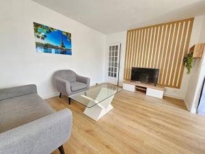 un soggiorno con divano e TV di Charmant appartement proche Paris a Épinay-sur-Seine