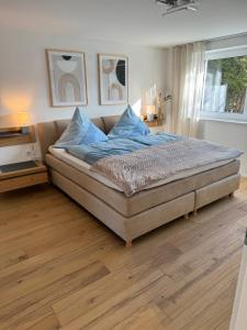 a bedroom with a large bed with blue pillows at Alpinsuite - modern - elegant in Waltenhofen
