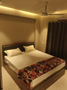 a bedroom with a large bed with a ceiling at Gandhi Villa in Daman