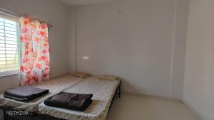 um quarto com uma cama com duas almofadas em Aadishkti bhakt nivas em Tuljapur