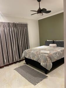 a bedroom with a bed and a ceiling fan at Immaculate Morden Scenic Villa in Ezulwini