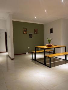 a room with a table and a bench in it at Immaculate Morden Scenic Villa in Ezulwini