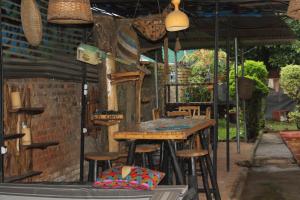 an outdoor bar with stools and umbrellas at Amahoro Guest House in Ruhengeri