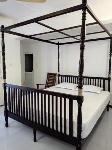 a bedroom with a large black canopy bed at The Duchess Hotel in Matara