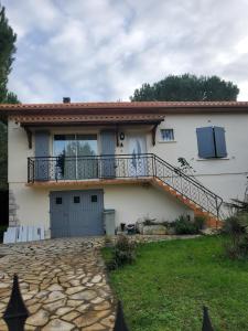 a house with a balcony on the side of it at La Villa du MOULIN DE MADAME in Bias