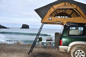 a tent on top of a jeep on the beach at Overland Madeira in Santana