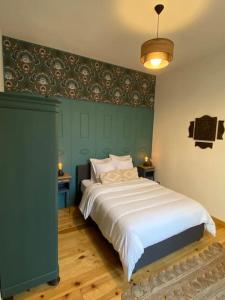 1 dormitorio con 1 cama grande y pared verde en Cocon cosy dans la ville rose, en Toulouse