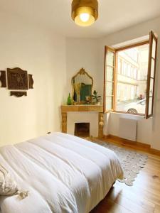een slaapkamer met een wit bed en een raam bij Cocon cosy dans la ville rose in Toulouse