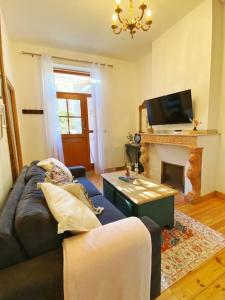 uma sala de estar com um sofá e uma lareira em Cocon cosy dans la ville rose em Toulouse