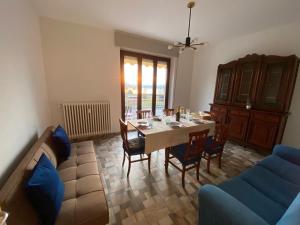 sala de estar con mesa y sofá azul en Appartamento Bellavista - Fronte Lago di Varese en Gavirate