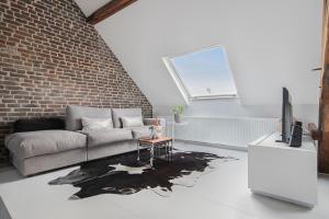 a living room with a couch and a brick wall at Pastoria Residence in Maastricht