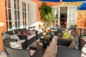 an outdoor patio with wicker chairs and tables at Odysseus Palace in Póros Kefalonias