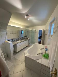een grote witte badkamer met een bad en een wastafel bij Spacious and stylish Apartment in Zurich in Zürich