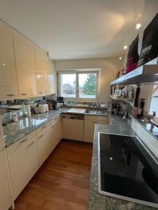 a large kitchen with white cabinets and a window at Spacious and stylish Apartment in Zurich in Zürich