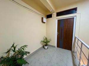 a corridor of a house with a door and plants at CityView Homestay in Imphal