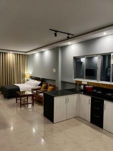 cocina y sala de estar con sofá y mesa en CityView Homestay, en Imphal