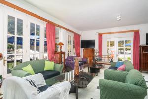 a living room with couches and chairs and windows at Odysseus Palace in Poros