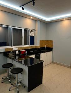 a kitchen with black counters and stools in a room at CityView Homestay in Imphal