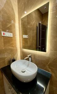 ein Badezimmer mit einem weißen Waschbecken und einem Spiegel in der Unterkunft CityView Homestay in Imphal