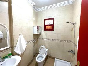 a bathroom with a toilet and a sink at Al Quba Al Thahbia Hotel Suites 2 in Riyadh