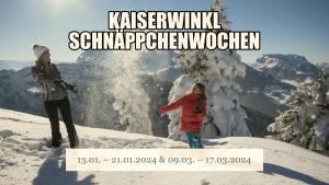 duas mulheres em pé no topo de uma montanha coberta de neve em Pension Essbaum em Walchsee