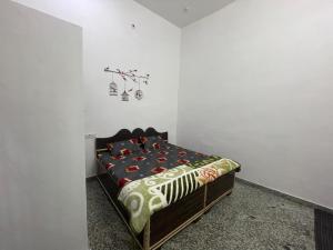 a bedroom with a bed in a white wall at Rukmani Villas Group of Rukmani home stay in Mathura