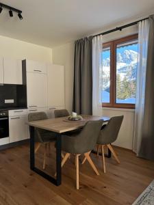 cocina con mesa y sillas en una habitación en Almappartement Nassfeld- Sonnenalpe, en Sonnenalpe Nassfeld