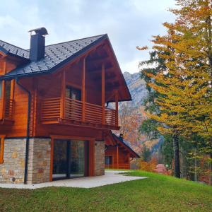 a log cabin with a balcony in the mountains at Kile Alpine Resort in Valbruna