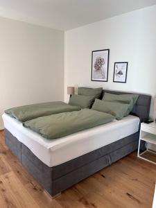 1 dormitorio con 1 cama grande con sábanas verdes y blancas en Almappartement Nassfeld- Sonnenalpe, en Sonnenalpe Nassfeld