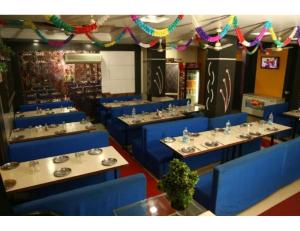 a restaurant with blue chairs and tables in a room at Hotel Bhagwati International, Abu Road, Rajasthan in Ābu Road