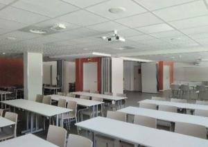 uma sala de aula vazia com mesas e cadeiras brancas em Domaine de Maravant - Centre de vacances em Thollon