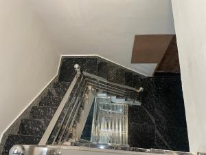 a stairway with black marble and a metal railing at Rukmani Villas Group of Rukmani home stay in Mathura