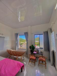 - une chambre avec un lit, un bureau et deux chaises dans l'établissement Homestay Tuyết Trinh, à Nha Trang
