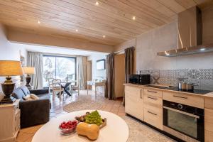 una cucina e un soggiorno con tavolo e frutta di Les Maisons de Montagne - Chez Marie a Pailherols