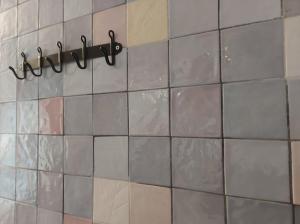 a tiled wall with a towel rack in a bathroom at Benedetto Cairoli Guest House in Bari