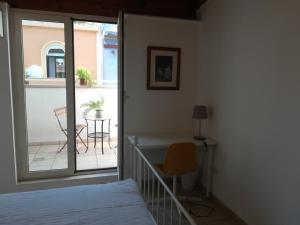 a bedroom with a bed and a balcony with a table at Benedetto Cairoli Guest House in Bari