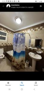 a bathroom with a shower curtain and a sink at Stanley Bridge apartment Alexandria in Alexandria